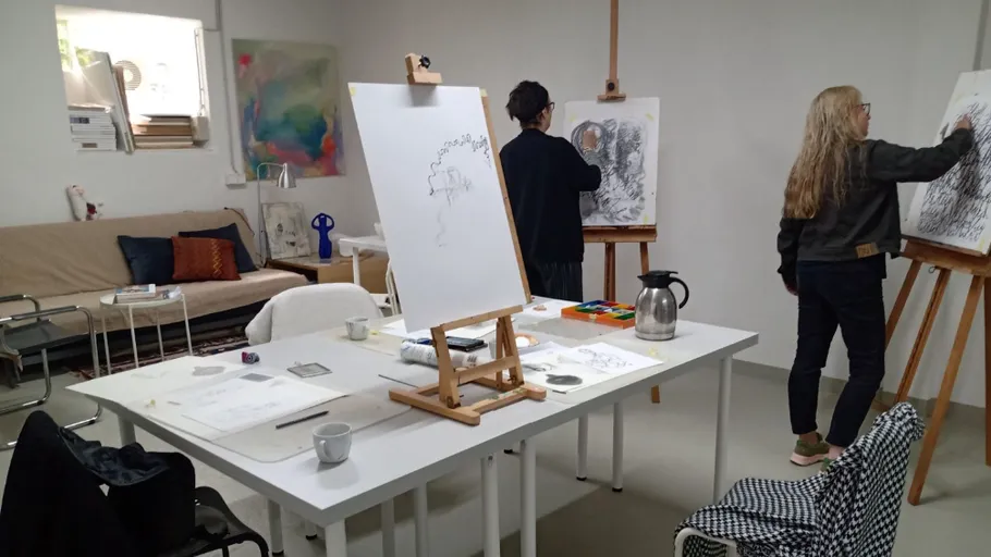 Zwei Künstler zeichnen an Staffeleien im Studio.