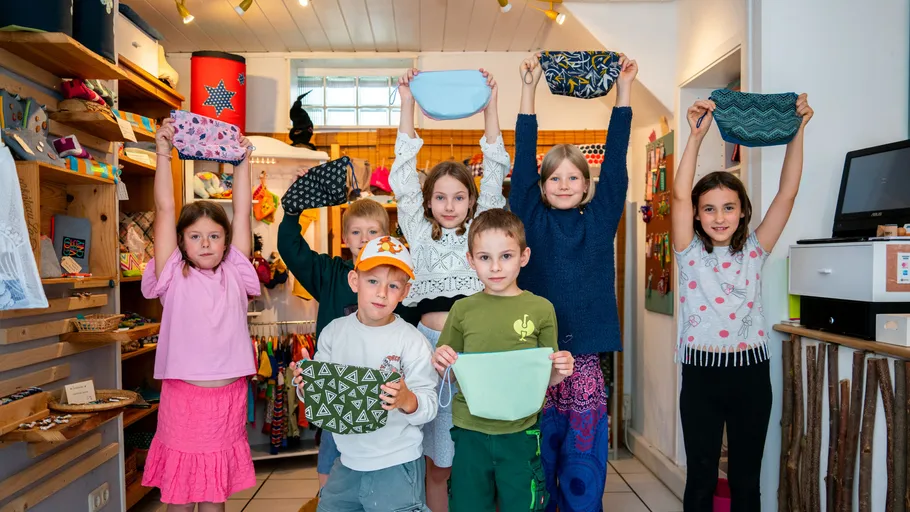 Kinder halten bunte Masken in einem Geschäft.