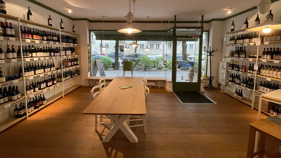 Weinladen-Interieur mit Holztisch und Regalen.