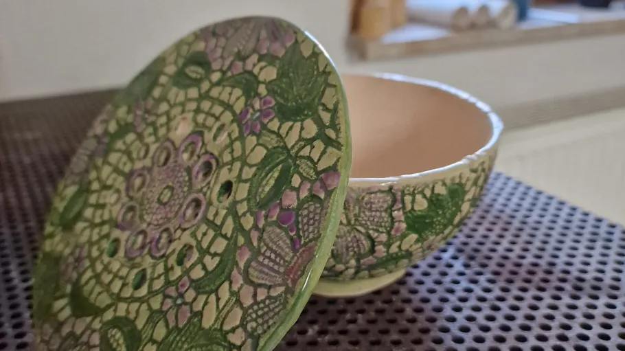 Ceramic bowl with decorative lid on table.