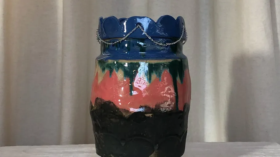 Bunter Keramikvase mit Kette aufgestellt.