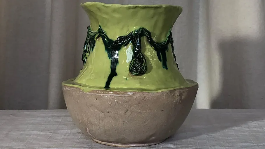 Keramikvase mit grünem und braunem Design.