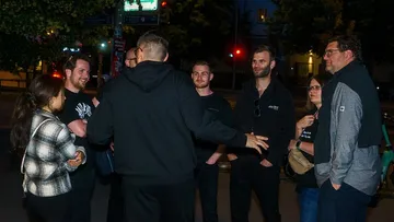 Gruppe von Menschen unterhält sich nachts im Freien.