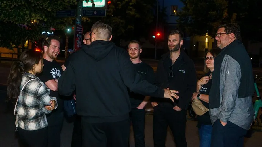 Gruppe von Menschen unterhält sich nachts im Freien.