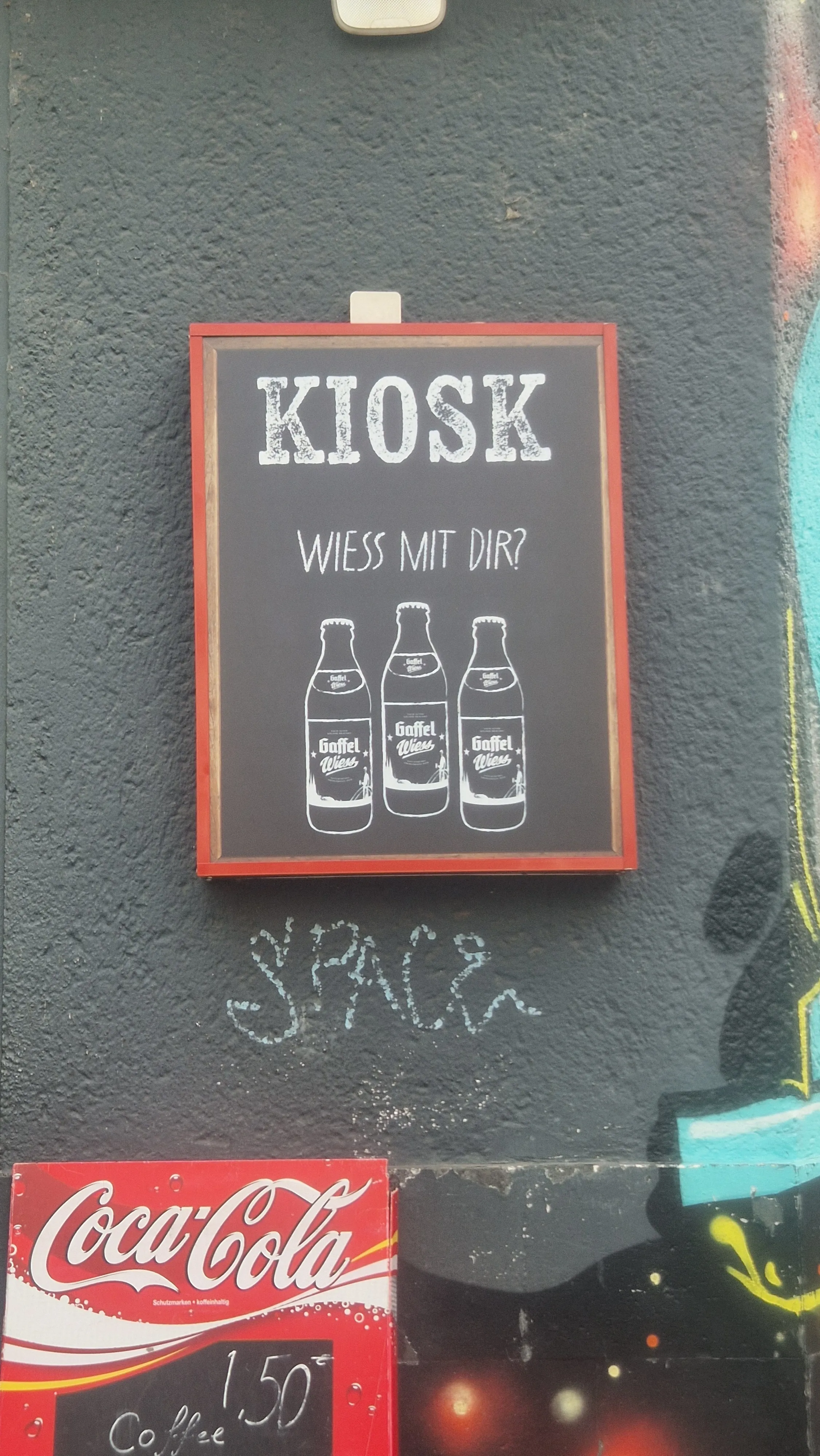 Sign with three bottles, wall graffiti.