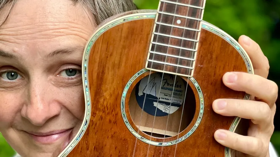 Person hält Gitarre nah ans Gesicht.