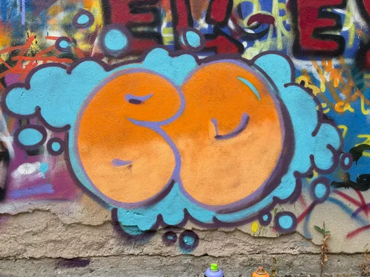 Bunte Graffiti-Buchstaben auf strukturierter Wand.