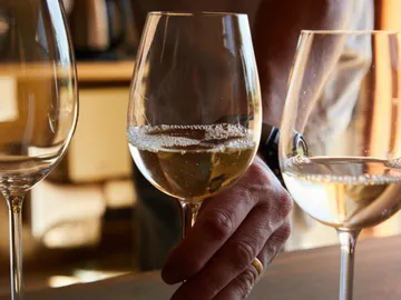 Ein Glas Sekt wird von einer Hand gehalten.