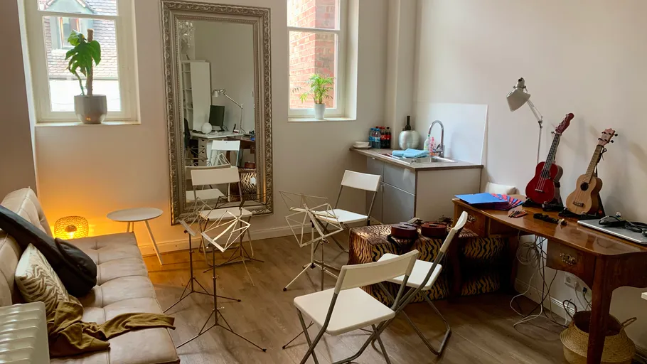 Music room with instruments and seating area.