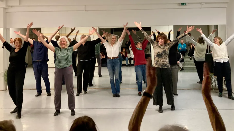 Personen heben Arme in Tanzkursstudio.
