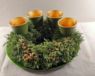 Green wreath with four gold candle holders.