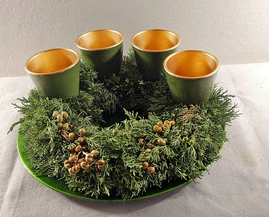 Green wreath with four gold candle holders.