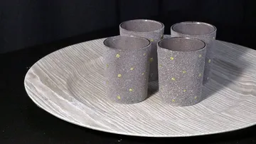 Four gray cups with yellow dots on tray.