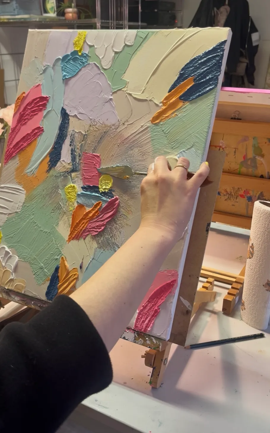 Hand painting colorful abstract canvas on easel.