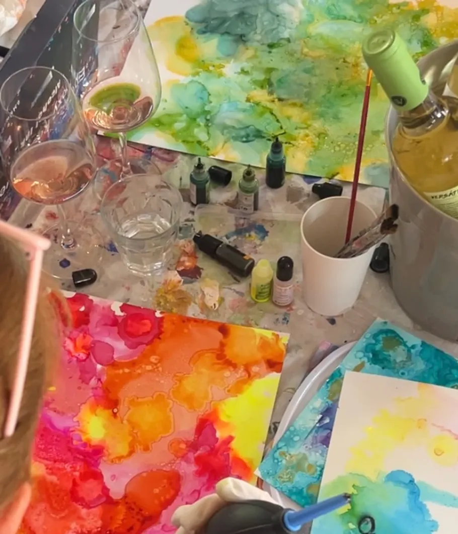 Person creates colorful abstract painting with wine glasses.