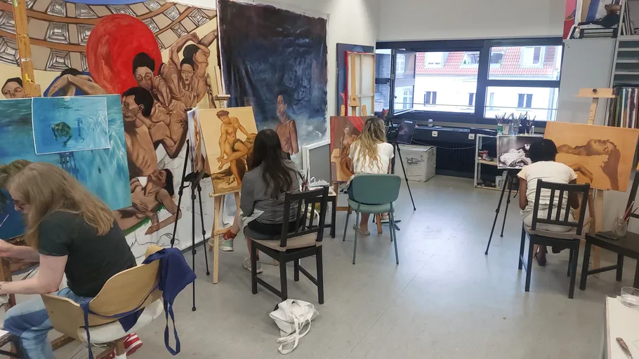 Künstler malen im Atelier mit bunten Kunstwerken.