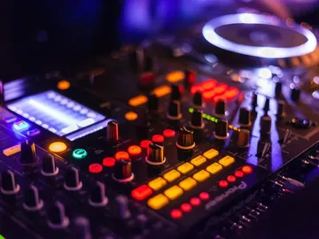 DJ-Controller leuchtet, Bedienelemente werden während einer Performance angepasst.