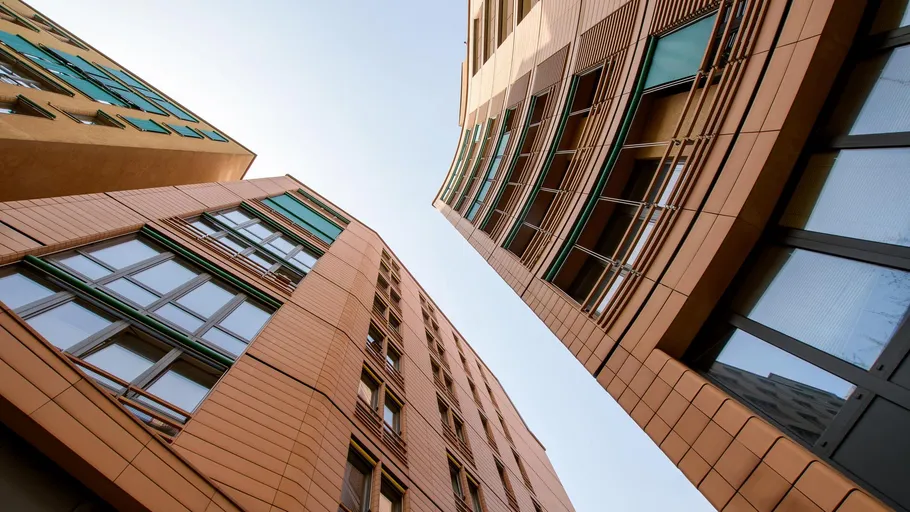 Tall modern buildings with glass facades against sky.