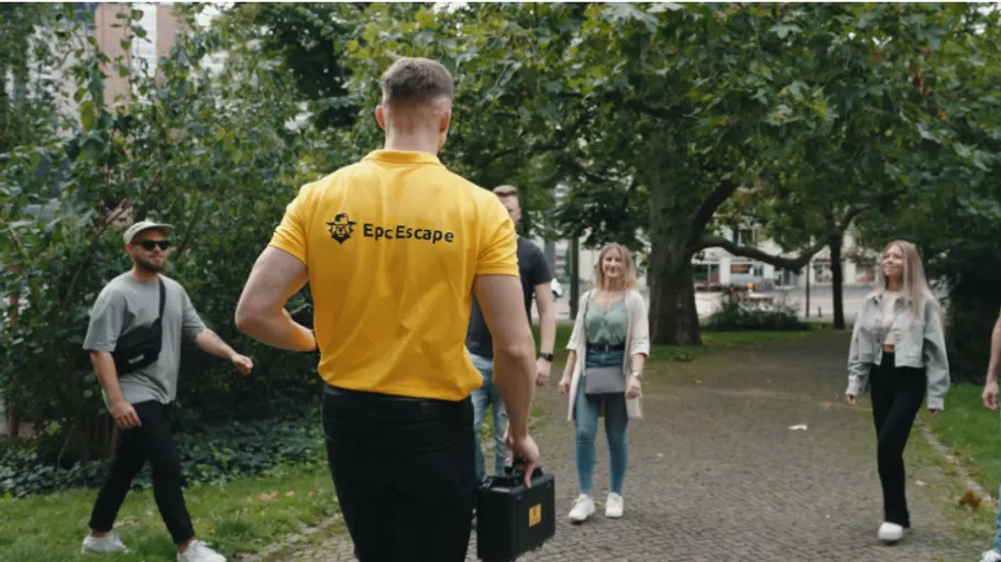Person im gelben Shirt führt Gruppe im Freien.