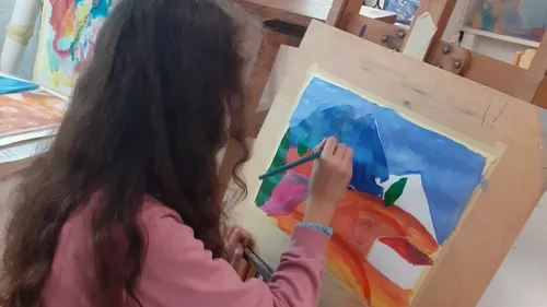 Child painting colorful art at easel.