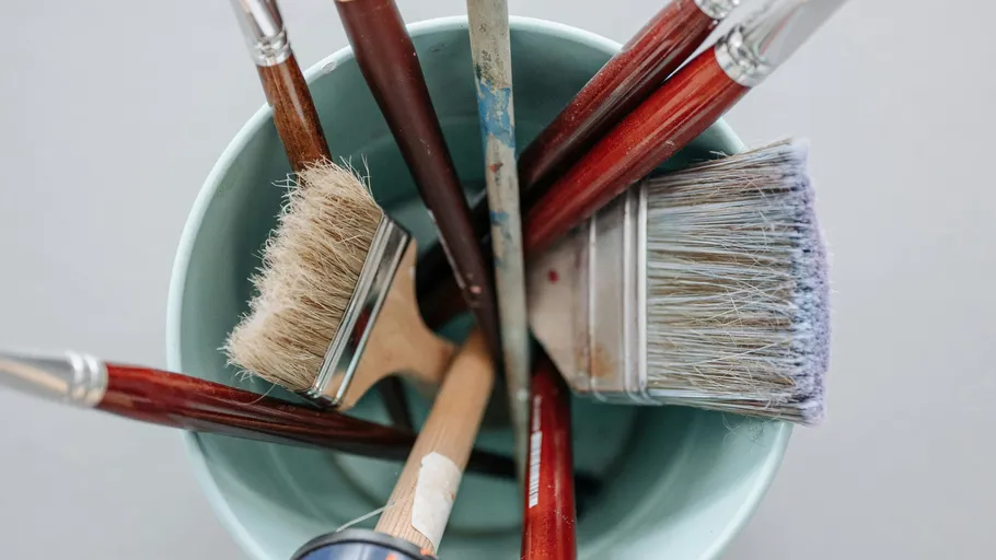 Paintbrushes in a cup on a table.