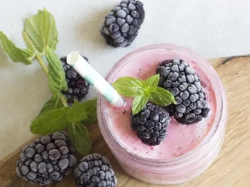Smoothie mug topped with berries and mint