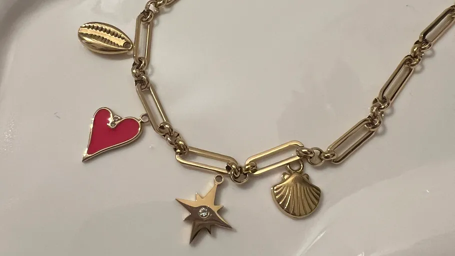 Gold necklace with various shaped charms.
