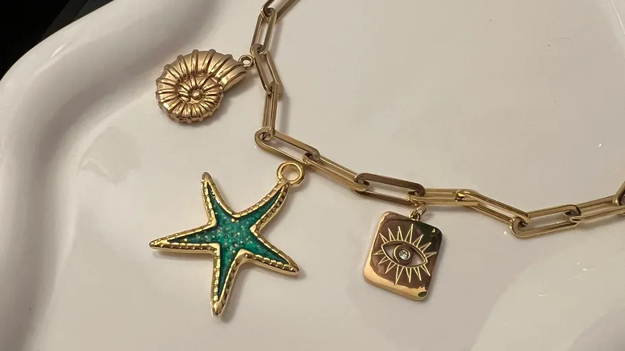 Goldene Kettenarmband mit verschiedenen Anhängern.