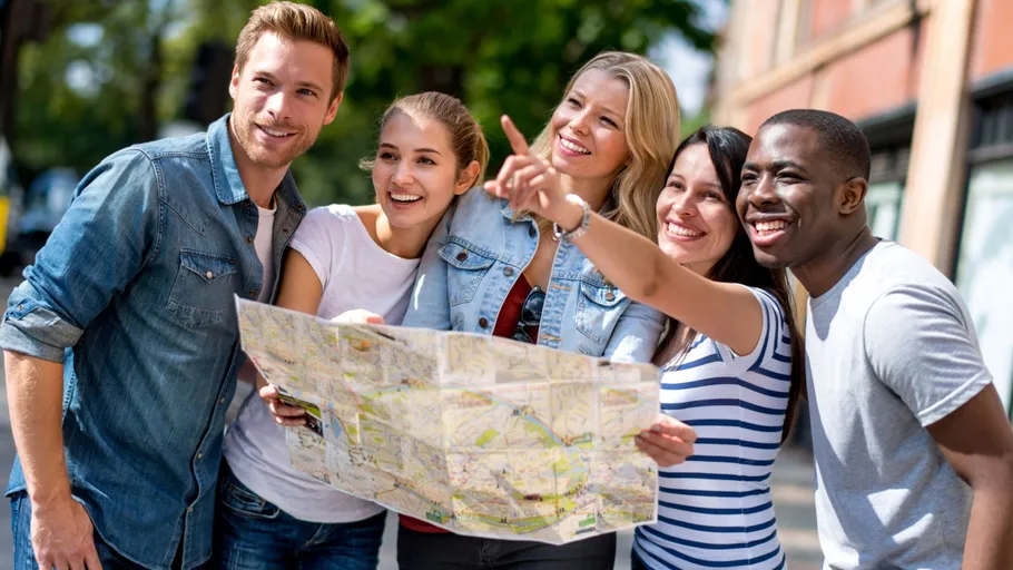 Gruppe von Freunden mit Karte draußen.