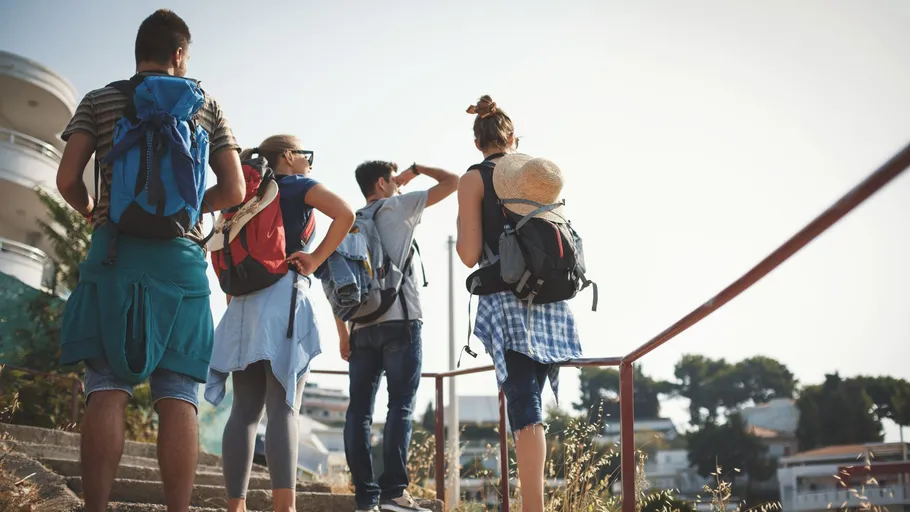Group hiking on sunlit stairs, outdoors.