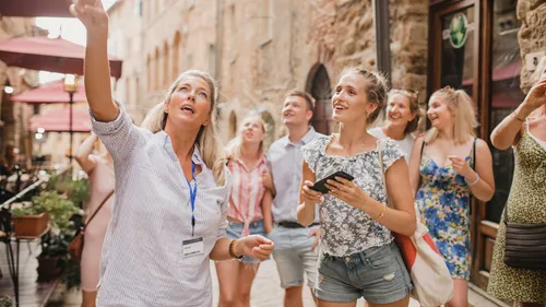 Group touring with guide on European street.