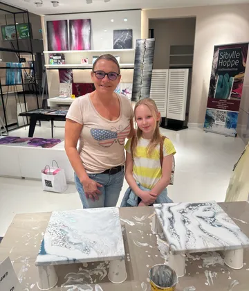 Zwei Personen posieren in einem Kunststudio.