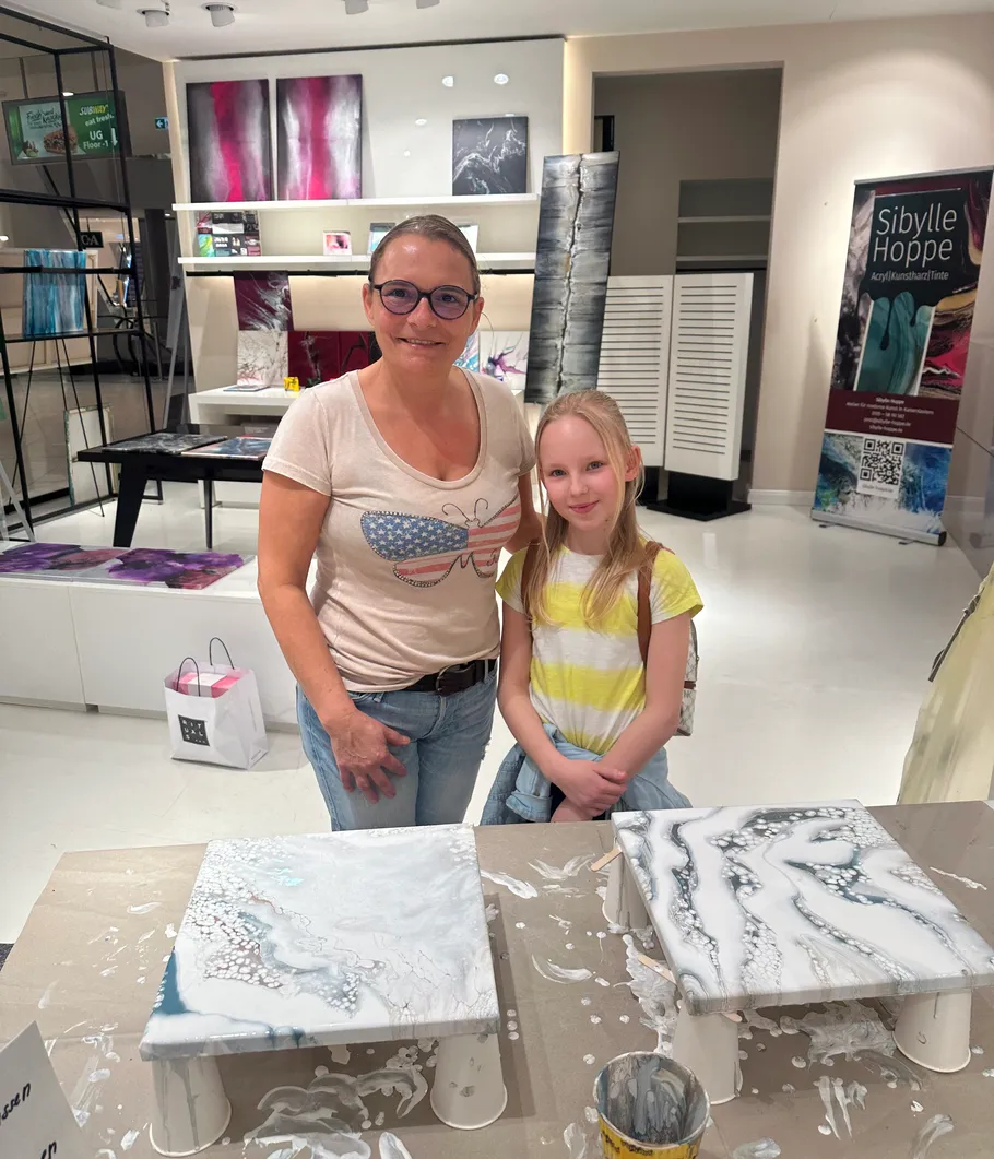 Zwei Personen posieren in einem Kunststudio.
