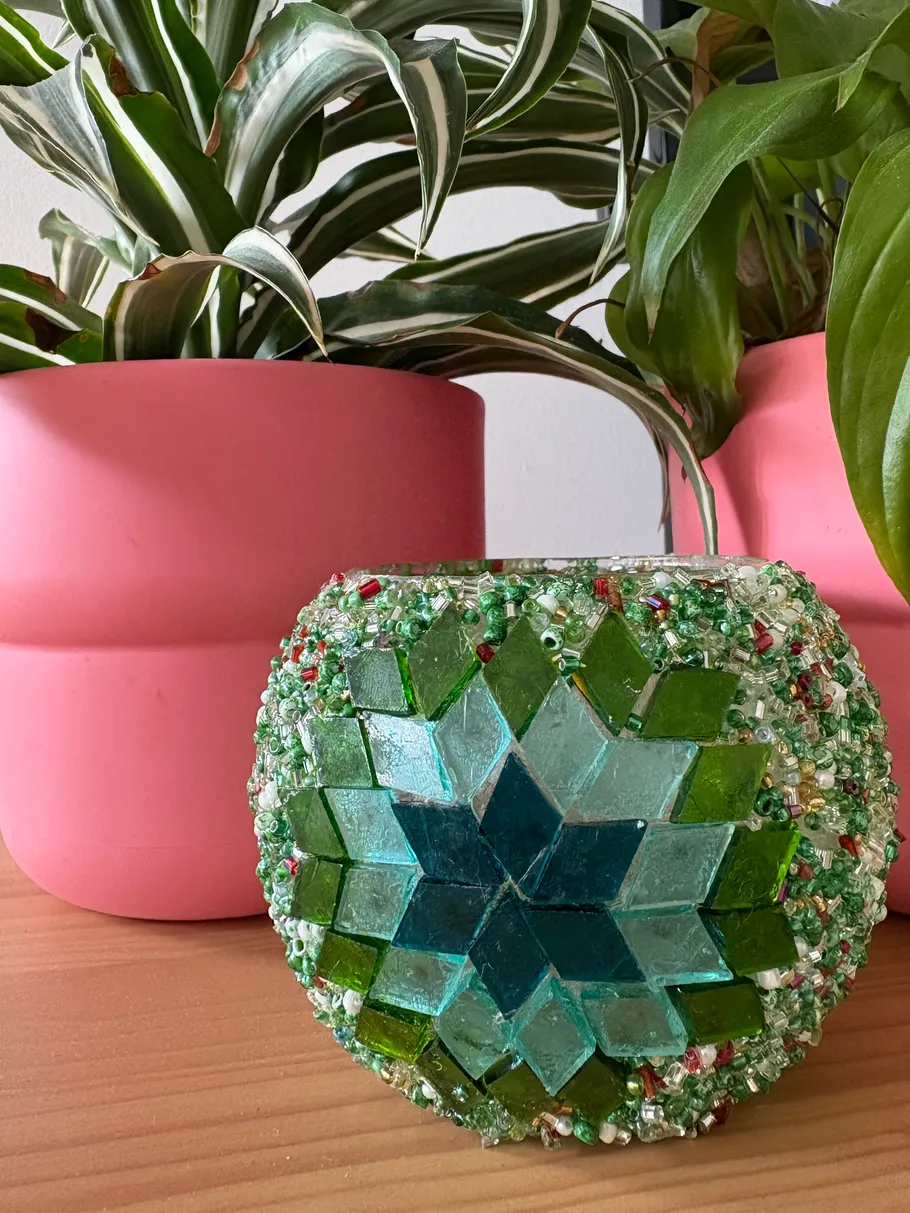 Bunter Mosaik-Kerzenhalter auf Holztisch.