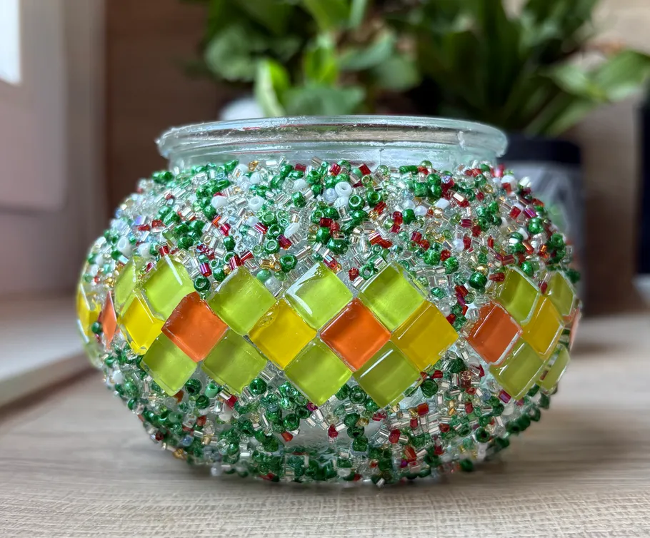 Glas-Kerzenhalter mit bunten Perlendekorationen.