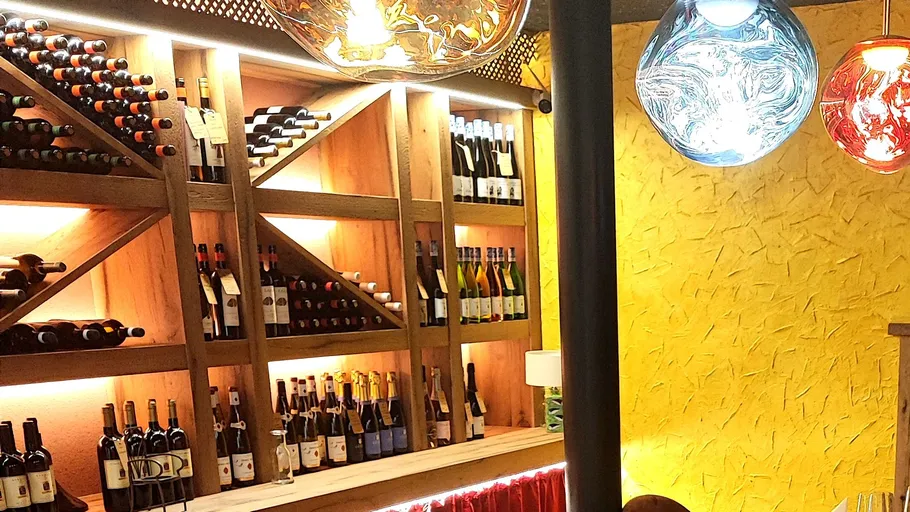Wine bottles on a decorated wooden shelf.