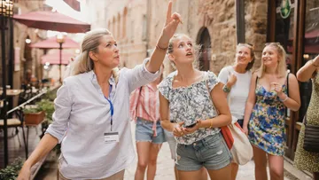 Group on tour with guide pointing upward.