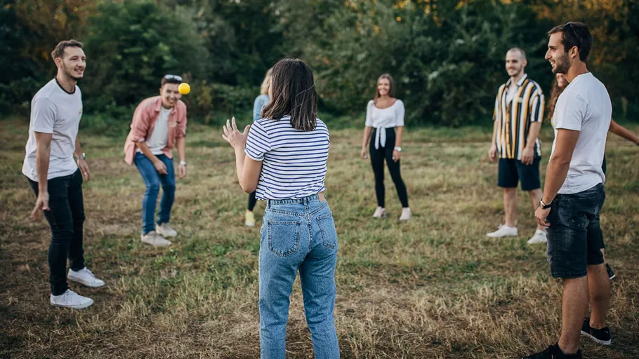 Menschen im Kreis spielen fangen im Freien.