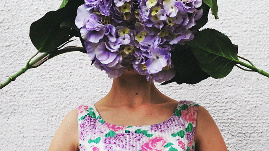 Person mit Hortensienstrauß als Kopf, Blumen-Kleid.