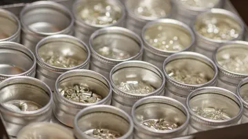 Metal containers holding small silver pieces.