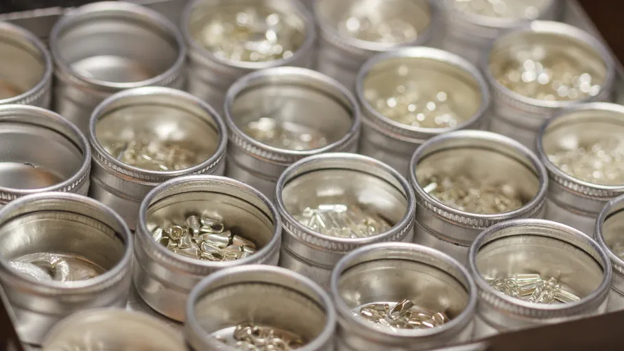 Metal containers holding small silver pieces.