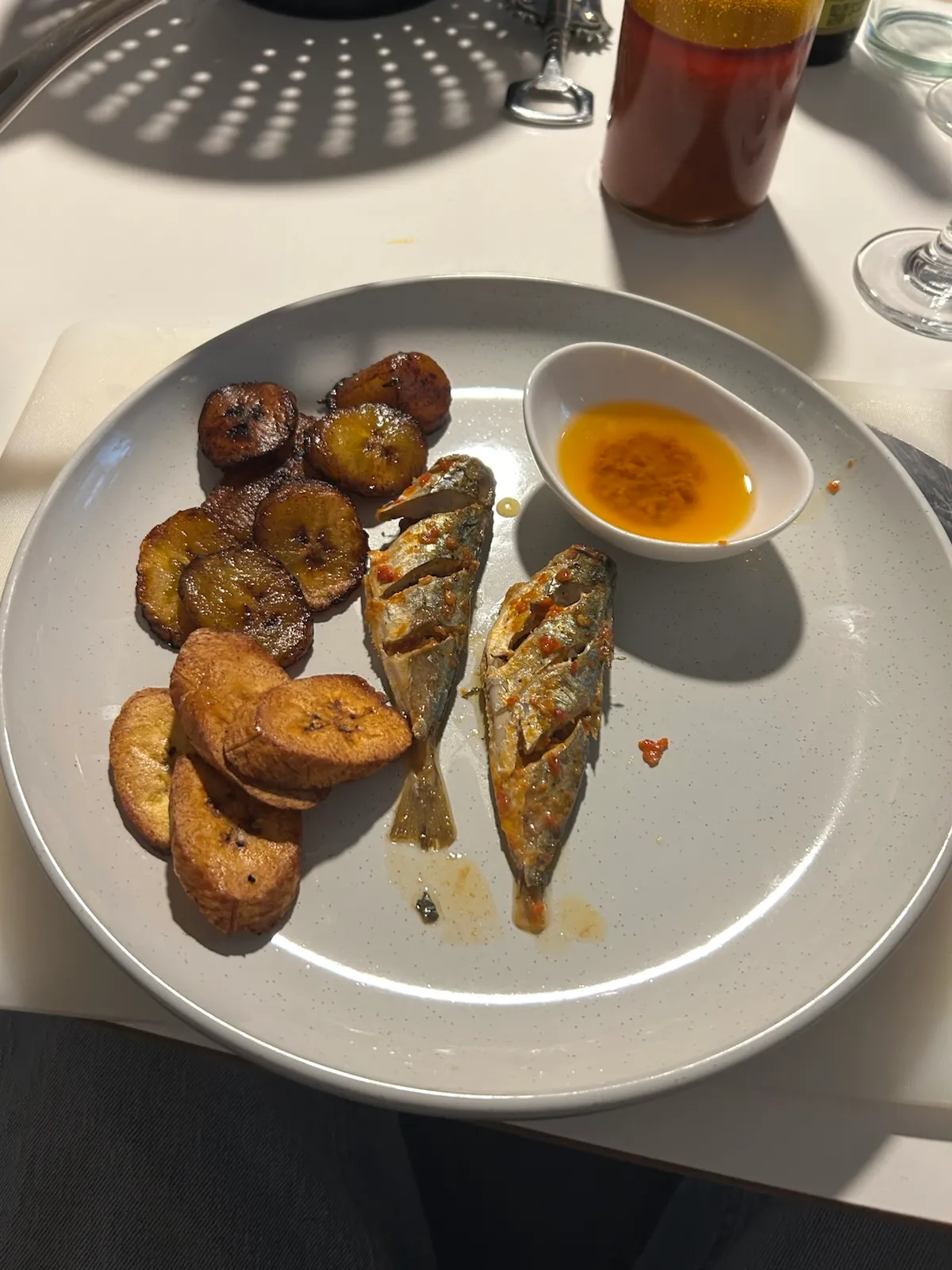 Fried fish and plantains on a plate.