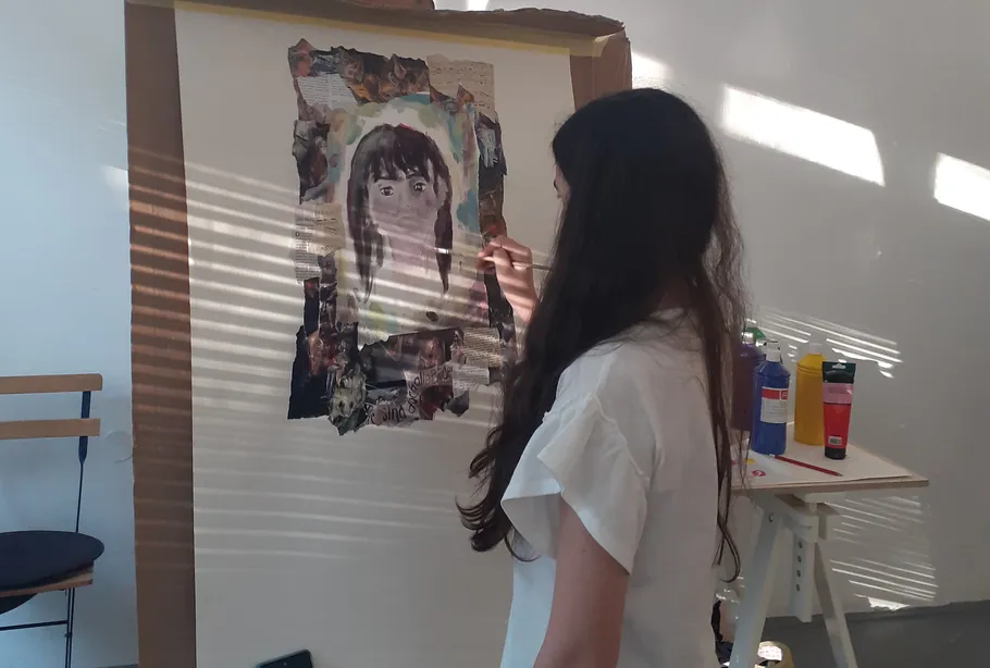 Person painting a portrait indoors with light stripes.