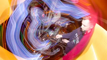 DJ mixing music with swirling lights.
