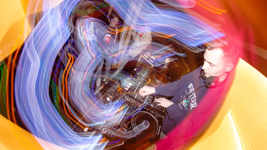 DJ mischt Musik mit wirbelnden Lichtern.