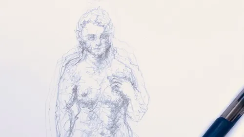 Scribbled figure drawing beside a pen.