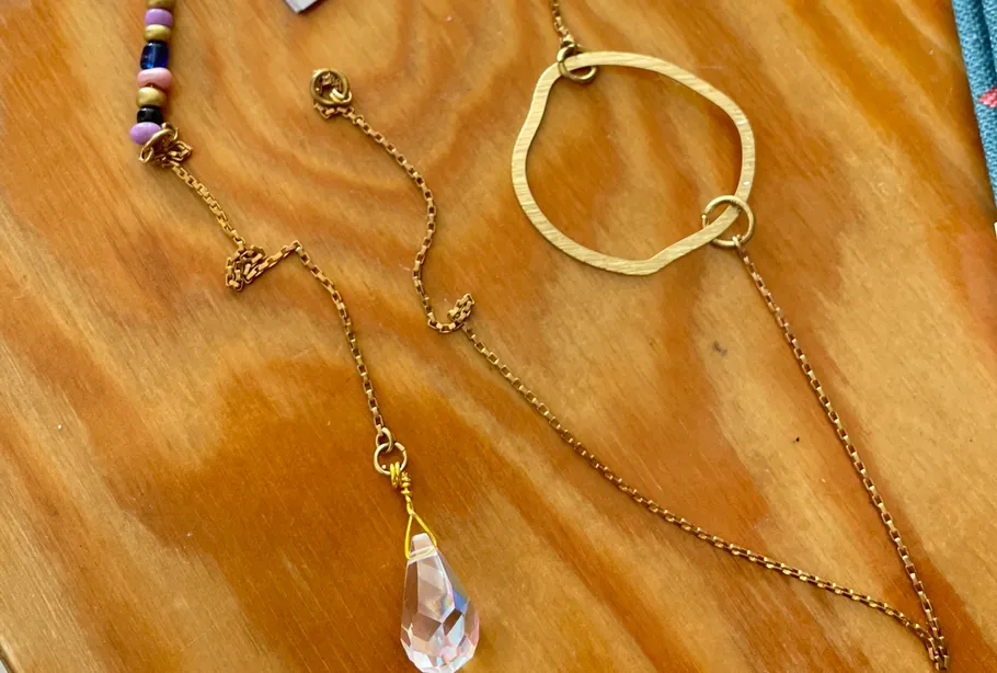 Jewelry pieces on wooden surface, shining brightly.