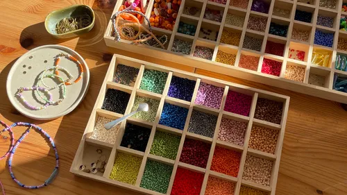 Perlen in Kästen auf Holztisch organisiert.