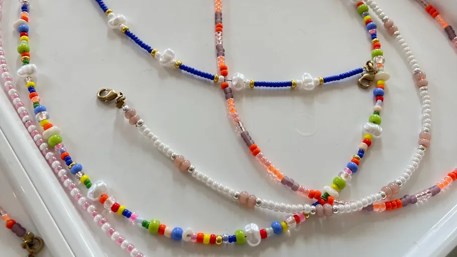 Bunte Perlenketten mit Verschlüssen ordentlich präsentiert.