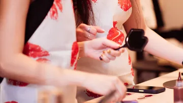 Women examining cosmetics at a counter.